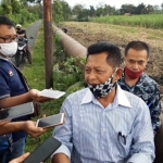 Kades Jambean H. Hari Amin didampingi kuasa hukumnya, Samsul Arifin, S.H., M.H. saat memberi keterangan di lokasi pipa air yang dipermasalahkan. foto: MUJI HARJITA/ BANGSAONLINE