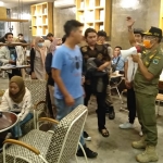 Kasatpol PP Kota Malang Priyadi bersama tim gabungan saat menyosialisasikan SE Wali Kota Malang nomor 6 Tahun 2020. Petugas membubarkan pengunjung Cafe Rocketo, di Jalan Kendalsari Kelurahan Tulusrejo, Lowokwaru Kota Malang untuk antisipasi penyebaran Virus Corona, Sabtu (21/03) malam. foto: IWAN IRAWAN/ HARIAN BANGSA