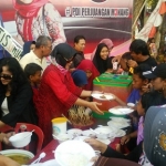 Ketua PDIP Gresik Ir. Hj. Siti Muafiyah melayani warga yang ingin makan gratis. foto: SYUHUD/ BANGSAONLINE