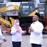 Bupati Gresik, Fandi Akhmad Yani, bersama wakilnya, Aminatun Habibah, saat menerima CSR excavator dari Bank Jatim. Foto: SYUHUD/BANGSAONLINE