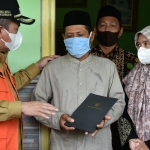 Wabup Pasuruan KH. Mujib Imron menyerahkan bantuan kepada Sutomo, orang tua korban.