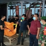 Petugas saat mengevakuasi tubuh korban ke mobil ambulans. foto: MUJI HARJITA/ BANGSAONLINE