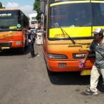 Tampak bus jurusan Dampit - Malang dan sopirnya, Bunayar (52), sedang santai mencuci bus. Ia tak menghiraukan kendati petugas UPT PPP LLAJ Dishub Jatim yang sedang menertibkan angkutan umum agar masuk ke terminal Hamid Rusdi, Senin (09/12). foto: IWAN IRAWAN/ BANGSAONLINE