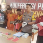 Kapolres AkBP Feby DP Hutagalung saat menunjukkan senjata api rakitan yang diamankan beserta kedua tersangka.
