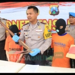 Kapolres Kediri AKBP Roni Faisal memegang cangkul yang digunakan mengubur bayi didampingi Wakapolres dan Kasatreskrim saat menggelar rilis sepasang kekasih yang tega bunuh bayinya sendiri. foto: ARIF K/ BANGSAONLINE