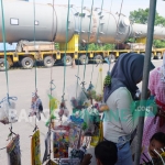 Salah satu pedagang yang mendadak membuka lapak di Jembatan Timbang Desa Sraturejo, Kecamatan Baureno, tepat di samping multi axle truck pengangkut selexol parkir. foto: EKY NURHADI/ BANGSAONLINE