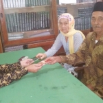 PASANGAN BAHAGIA: Mbah Muri dan Mbah Lasi saat menerima buku nikah dari penghulu.