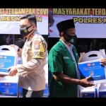 Kapolres Madiun AKBP Jury Leonard Siahaan membagikan bansos di Joglo Mapolres Madiun.