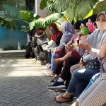 Para calon mahasiswa menunggu antrean rapid test di sisi tempat parkir di pinggir jalan Dharmawangsa.