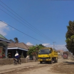 Beberapa truk dengan muatan pasir saat melewati jalan di permukiman warga. Foto: ARIF K/BANGSAONLINE