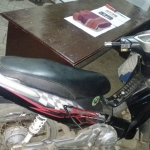 Tersangka pembunuh Metty alias Slamet Pujianto (di balik motor) dengan kaki kanan terbalut akibat berusaha kabur. Petugas juga mengamankan barang bukti berupa sangkur berada di atas meja.