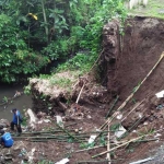 Petugas Tagana terlihat memasang sesek dan karung pasir di lokasi longsoran plengsengan Kali Ngegong. foto: Akina/ BANGSAONLINE