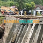 Penahan badan jalan yang ambrol akibat terkikis aliran sungai. Foto: BAMBANG DWI JULIANTO/BANGSAONLINE
