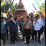 Bupati Sambari (dua dari kiri) dan Wabup Qosim (dua dari kanan) saat menggotong gunungan sedekah bumi di Desa Kedanyang, Kebomas. foto: SYUHUD/ BANGSAONLINE