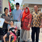 Penderita cerebral palsy, Zahra Aqilla Putri (12), saat menerima bantuan kursi roda dari Baznas Sidoarjo.