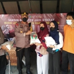 Kapolres Pamekasan, AKBP Rogib Triyanto, saat memantau gerai vaksin dan sempat menyerahkan paket sembako bagi masyarakat yang melakukan vaksinasi Covid-19. 