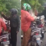 Tangkapan layar seorang pria berjaket hitam yang diduga seorang oknum polisi memukul kepala driver ojek online saat berhenti di pinggir jalan.