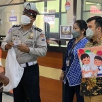 Personel Satlantas Polres Batu saat membagikan doorprize kepada para wajib pajak di KB Samsat Kota Batu.