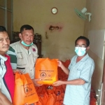 Petugas saat menyalurkan bantuan kepada korban banjir. (foto: ist)