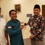 Komisioner KPU Jatim Divisi Perencanaan dan Data, Choirul Anam menyerahkan soft copy DPT Pemilu 2019 kepada perwakilan partai politik. foto: ist