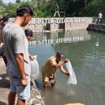 Penebaran benih ikan di salah satu sumber air di Kecamatan Ngasem. Foto: Ist.