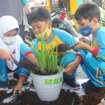 Siswa-siswi SD Al Muslim saat menanam pohon di Balai Desa Berbek, Waru, Sidoarjo. Foto: Ist.