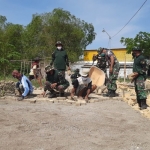 Babinsa Koramil 0817/09 Benjeng bahu-membahu membantu memperbaiki jalan di Dusun Benjeng, Desa Bulurejo, Kecamatan Benjeng, Kabupaten Gresik.