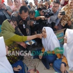 Menteri Kelautan dan Perikanan RI, Susi Pudjiastuti saat menyuapi seorang santri. foto: RONY S/ BANGSAONLINE