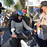 Kapolres Pamekasan bersama PJU Polres Pamekasan sedang membagikan masker ke salah satu pengguna jalan raya.