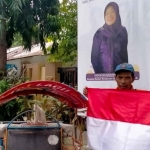 Seorang tukang becak saat menerima bendera merah putih. Foto: Ist