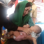 Pj Ketua Tim Penggerak PKK Nganjuk Eka Haryati Taruna saat meneteskan vaksin polio kepada salah satu balita.