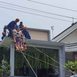 Petugas saat mengevakuasi pria yang tersengat listrik di Sidoarjo.