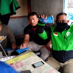 Sejumlah driver ojek online menunjukkan masker yang didapat secara gratis. 