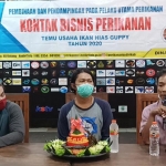 Plt Kepala Dinas Perikanan Kabupaten Kediri, Nur Hafidz (pegang mik) dan Ketua Sentra Guppy Kediri, Yakup Bastian sebelum acara potong tumpeng. foto: MUJI HARJITA/ BANGSAONLINE