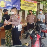 Anggota Satlantas Polres Pasuruan memberikan bubur kacang ijo dan telur rebus kepada para wajib pajak.