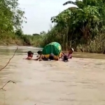 Keranda berisikan jenazah Nenek Kasti (71) saat menyeberangi anak Kali Lamong menggunakan ban bekas menuju lokasi pemakaman. foto: ist.