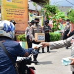 Polresta Sidoarjo dan jajaran masif melakukan penyemprotan disinfektan di berbagai wilayah serta pembagian masker ke masyarakat. (foto: ist)