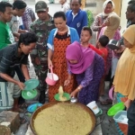 Puluhan warga rela mengantre demi mendapatkan bubur syuro. foto: GUNAWAN WIHANDONO/ BANGSAONLINE