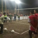 BUKA TURNAMEN: Ketua DPRD Sidoarjo H Sullamul Hadi Nurmawan melakukan serve (pukulan pertama) saat membuka Turnamen Bola Voli Mini, di Desa Simpang Kecamatan Prambon, Sidoarjo, Sabtu (8/7) malam. foto: MUSTAIN/ BANGSAONLINE