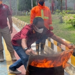 Petugas Lapas Kelas II A Pamekasan saat memeragakan cara memadamkan api menggunakan kain yang dibasahi.