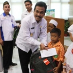 Wabup Qosim saat memberikan santunan kepada anak yatim. foto: SYUHUD/ BANGSAONLINE