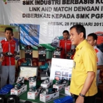 Direktur SDM dan Umum PT. PG Rahmad Pribadi saat menyerahkan bantuan peralatan kepada SMK PGRI 1 Gresik. foto: SYUHUD/ BANGSAONLINE