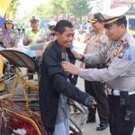 Kasatlantas Polres Pacitan, AKP J Nugroho saat memberikan jaket dan helm kepada pengguna jalan yang dinilai tertib. foto: yuyun/ BANGSAONLINE