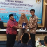 Evi Zaenal Abidin dan Edwin memberikan cinderamata kepada salah peserta seminar.