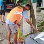 Salah seorang pelanggar prokes karena tidak memakai masker saat menjalani sanksi sosial dengan menyapu di tempat umum. foto: ist.