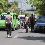 Petugas bersama para pengendara mengheningkan cipta sejenak saat sirine detik-detik proklamasi dibunyikan.