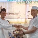 Ketua KWG M. Syuhud Almanfaluty menyerahkan potongan tumpeng kepada Ketua Panitia HPN KWG 2020, Sahlan Kurniawan. foto: ist.