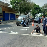 Pengecatan marka physical distancing di salah satu traffic light.