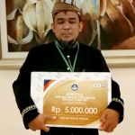 Nono Purnomo, Kepala Sekolah SMP Negeri 5 Kota Mojokerto, menunjukkan Piagam Penghargaan Tenaga Kependidikan Inspiratif dari Kemendikbud Ristek.