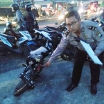 Petugas menunjukkan kondisi kendaraan Suzuki Satria yang terlibat kecelakaan.